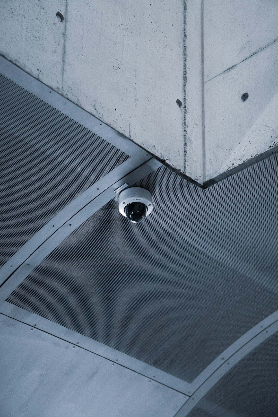 a-security-camera-mounted-to-the-ceiling-of-a-building-genixifkmc4